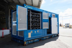 Hydrogen fuel generator tucked in a modified blue container with open doors shows the inner workings.