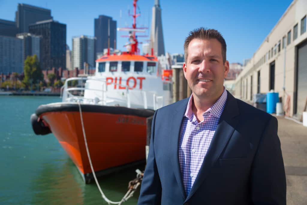 Dave Merritt stands in front of a pilot transfer ship docked in the San Francisco bay.