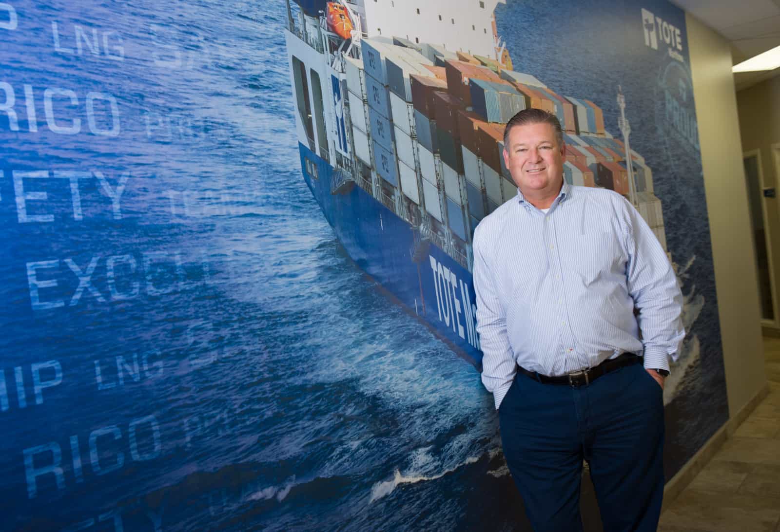Bob leans against a TOTE Maritime mural.