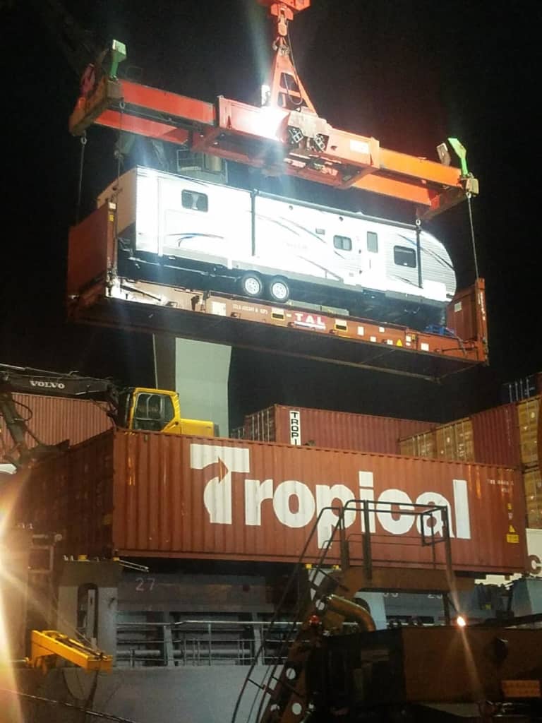 An RV trailer is lifted from a Tropical ship to be used by volunteers.