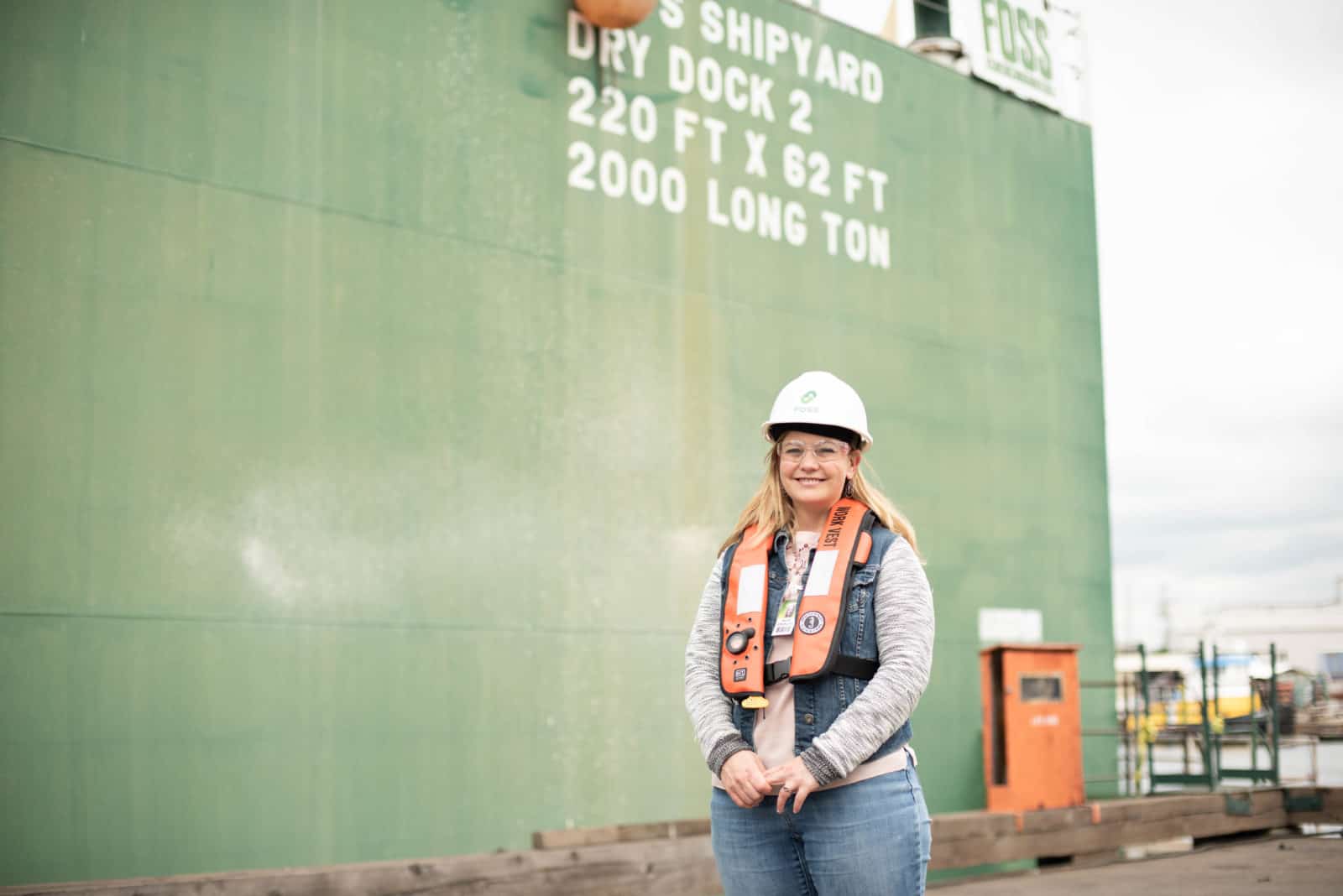 Amanda Dayton stands in front of one of the dry docks at the Foss Shipyard in Seattle