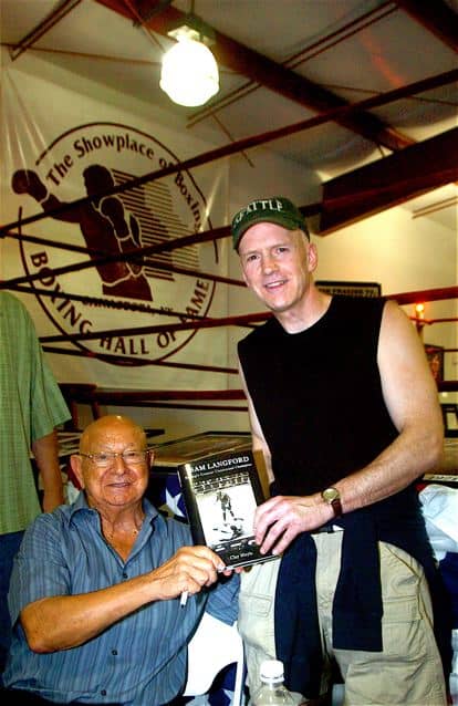 Clay Moyle, right, poses with Angelo Dundee, both hold Clay's book up for the photo.