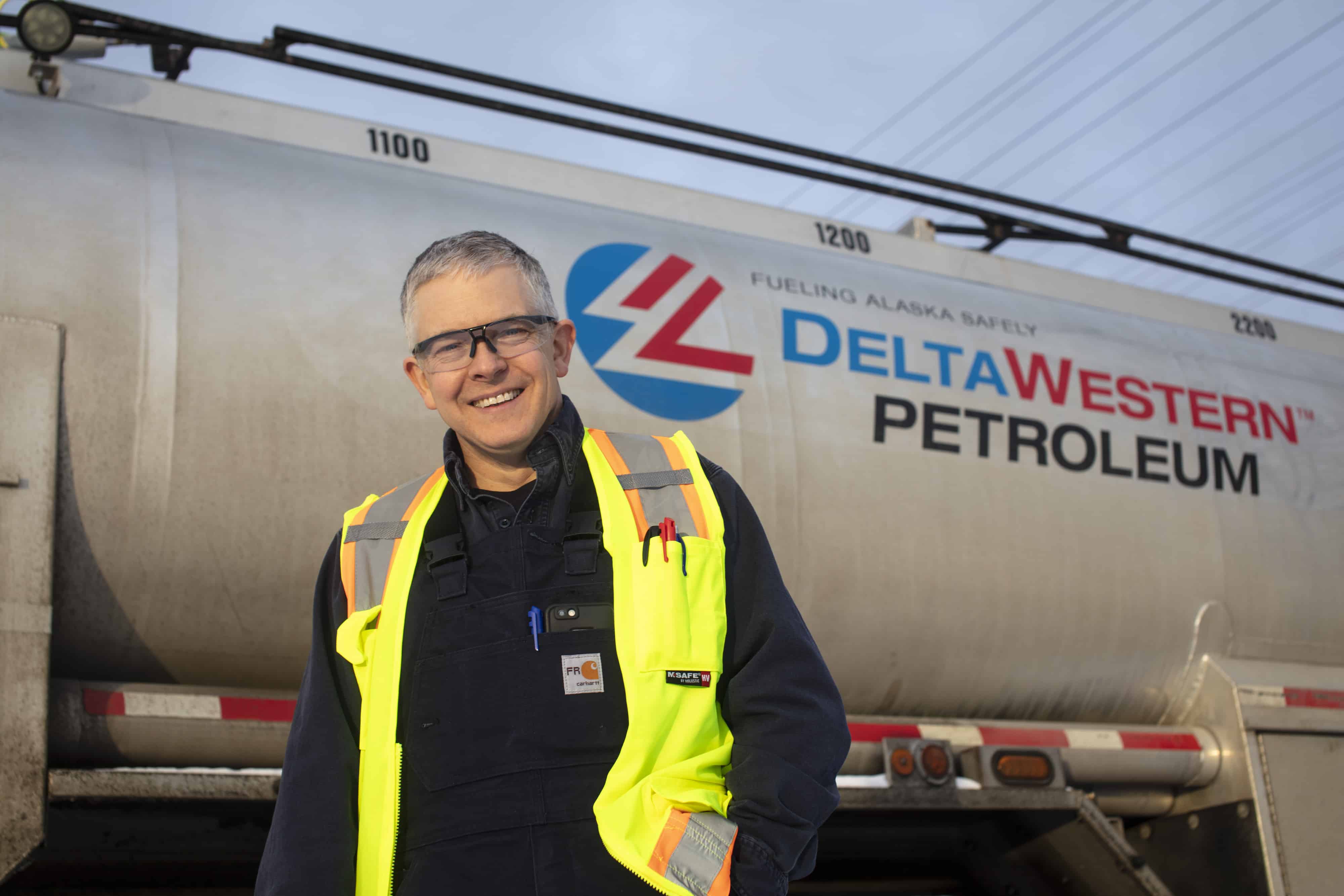 Deniss poses in front of a Delta Western Petroleum.