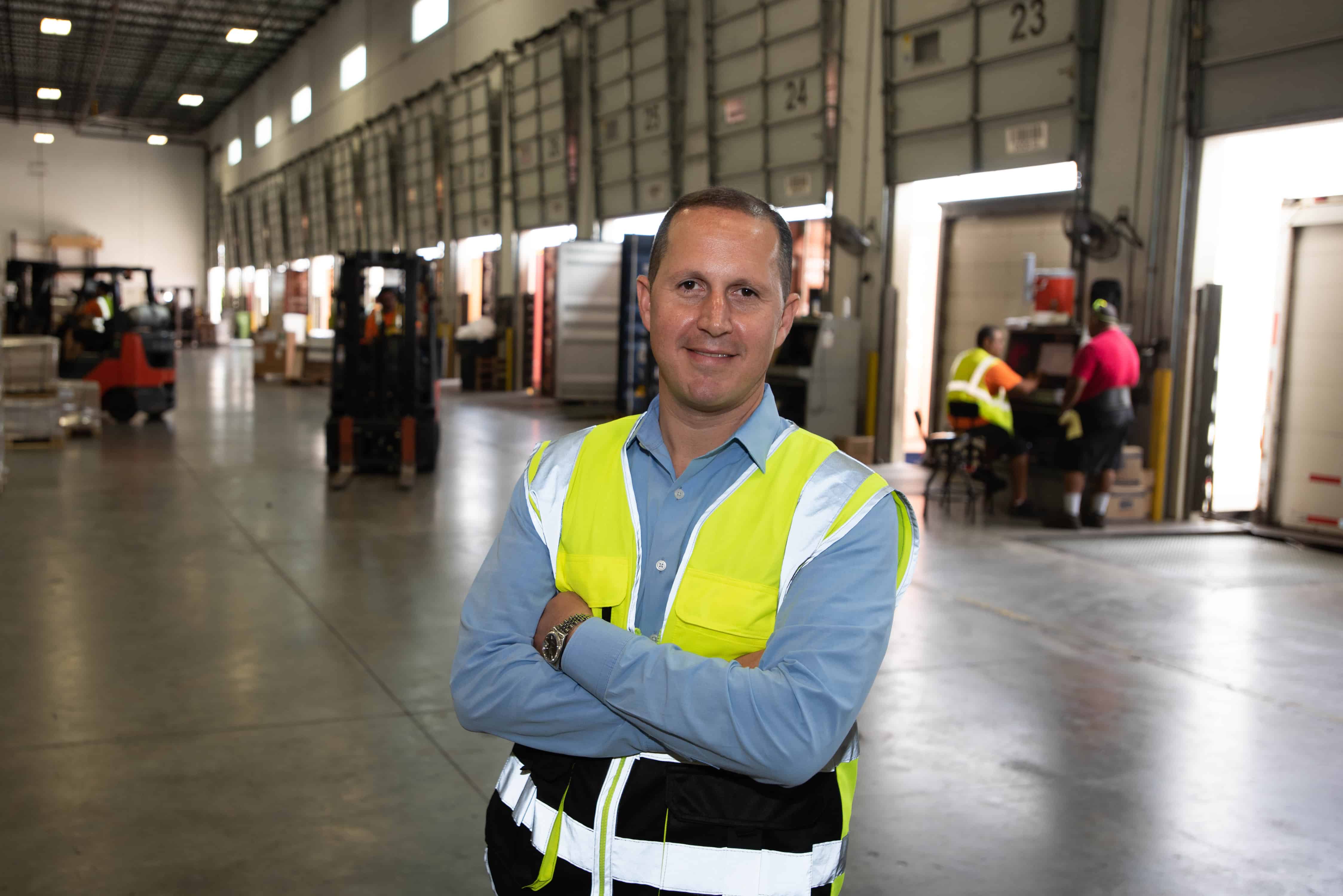 Dipietropolo wears a yellow reflective vest inside a Tropical warehouse.