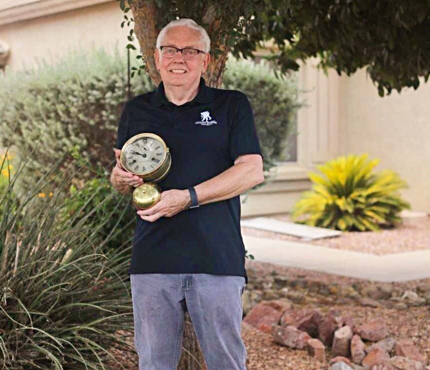 Richard holds an antique clock outside his home.