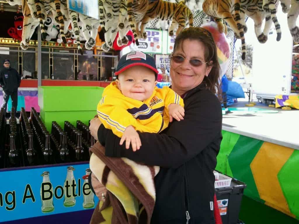 Debbie holds Weite's baby nephew at a carnival.