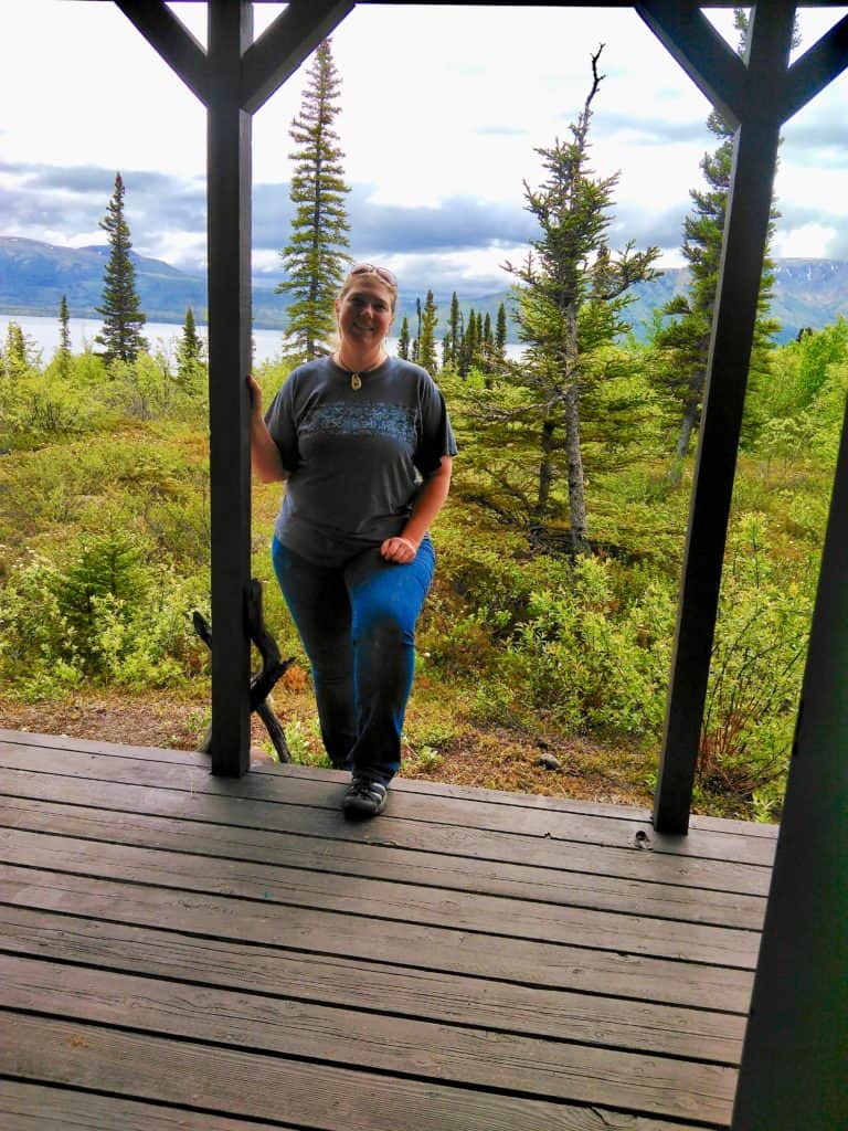 Anderson stands on her cabin deck overlooking a lake.