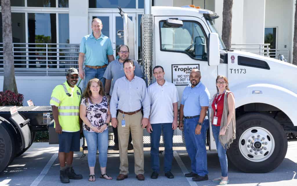 Kent and his team members pose in front of a Tropical truck.