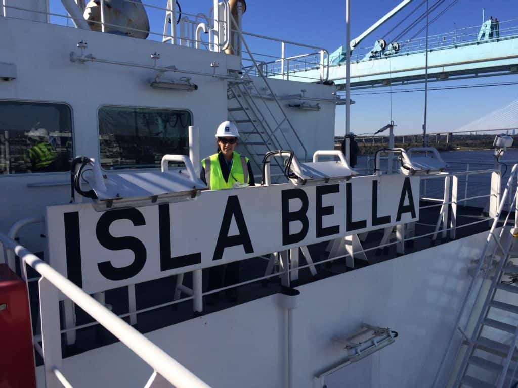 Vega poses on the Isla Bella in a green reflective vest and hard hat.