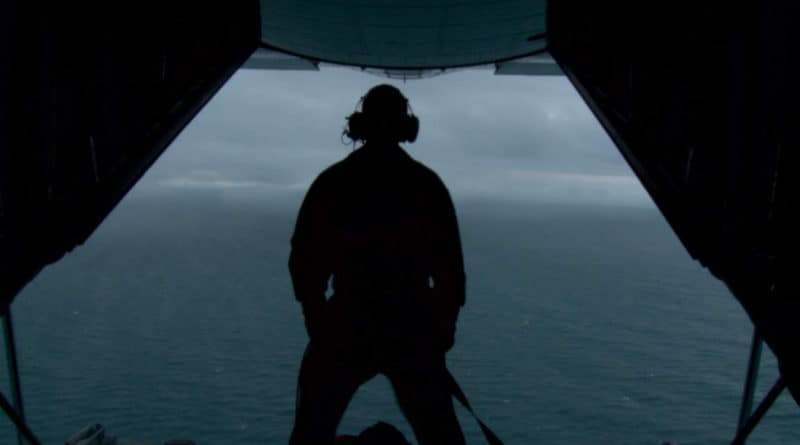 Lounsbery's silhouette is standing on the edge of a cargo plane's ramp.