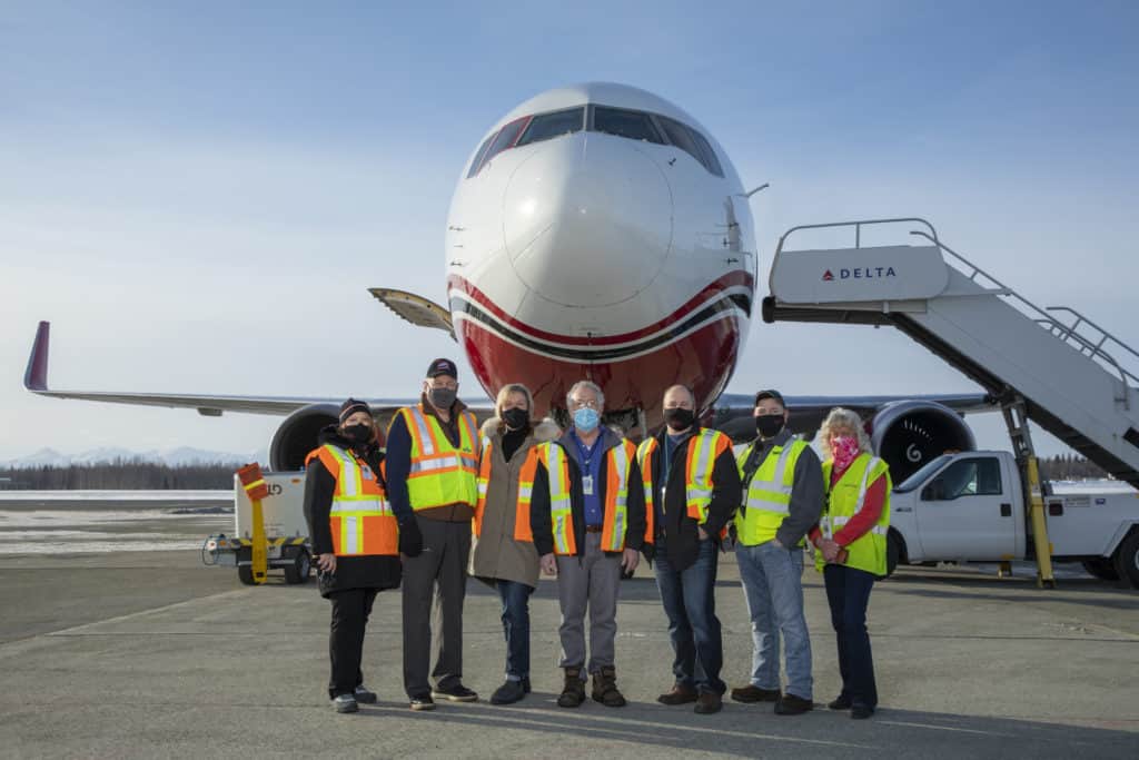 Seaton stands with fellow Saltchuk Aviation employees in front of a NAC cargo jet.