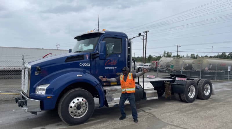 Tim Rogers poses with arms stretched out wide in front of his new Carlile truck.