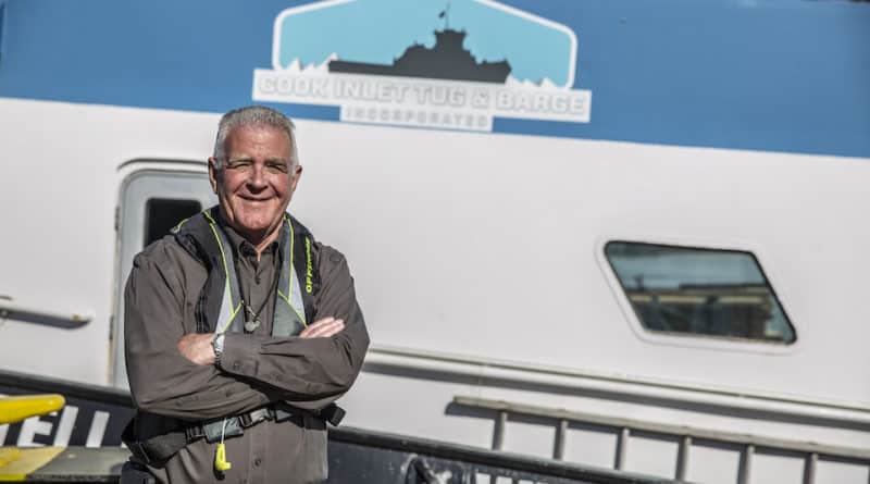 Mike O'Shea smiles and crosses his arms in front of a CITB boat.