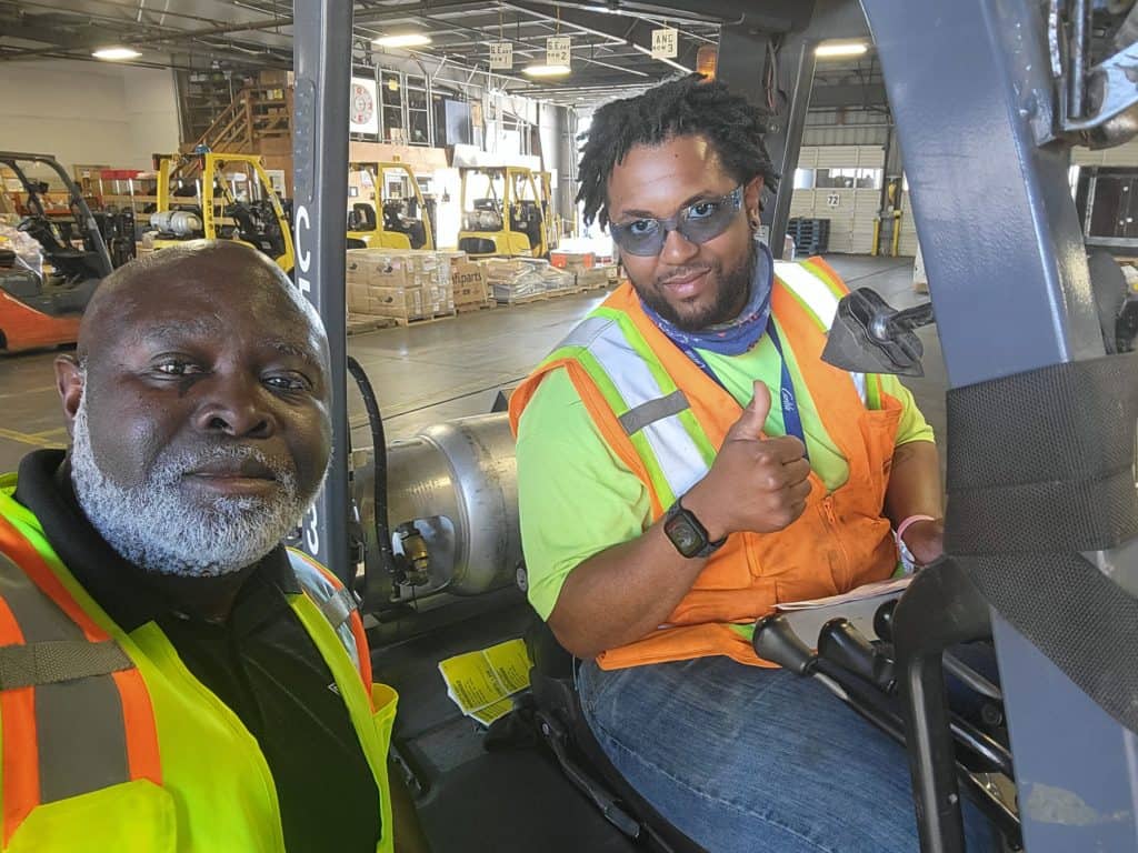 Lewis takes a selfie with a forklift driver in Tacoma.