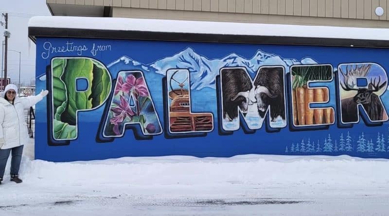 Leslie Hinton stands in front of a mural in Palmer, Alaska.