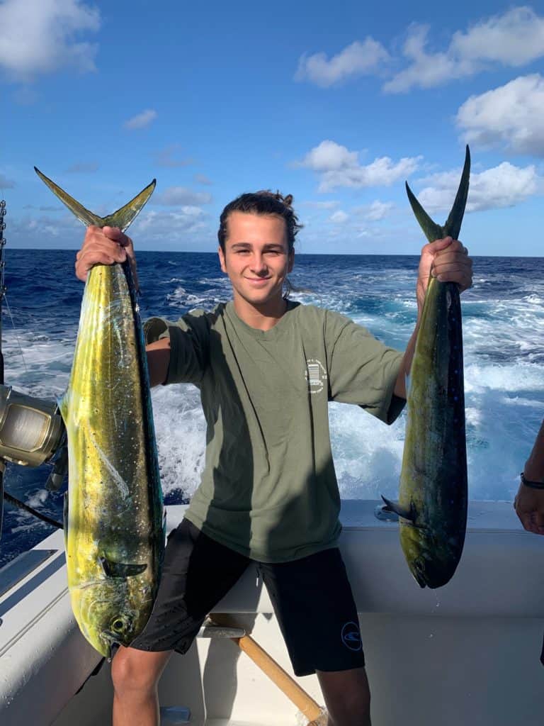 Pierce poses with two tropical fish he caught.